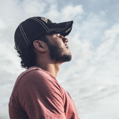 Ein fitter Man atmet umkreist mit einem weisen Himmel